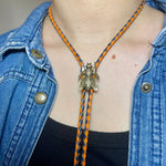 Load image into Gallery viewer, SOLD - Fly Bolo Tie – Orange &amp; Black Cord
